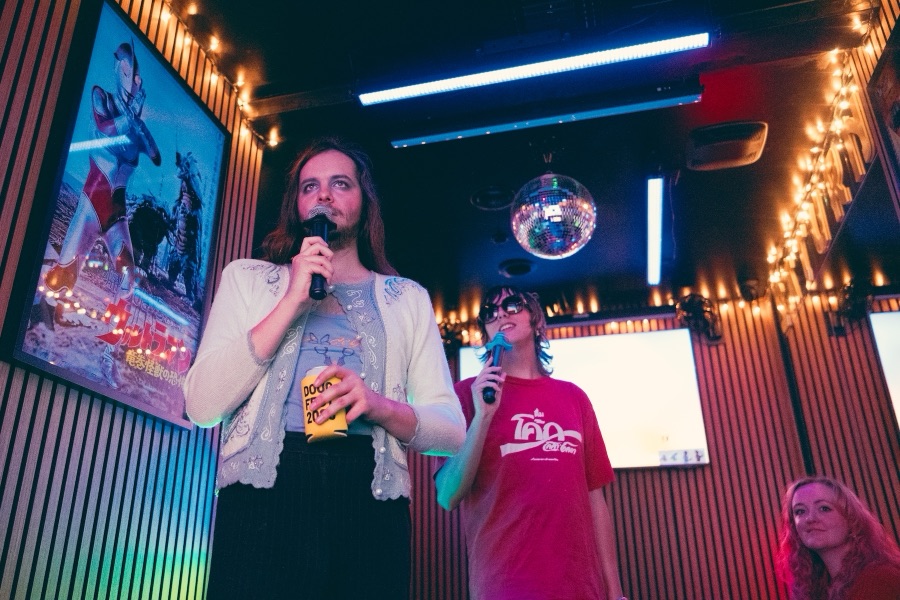 Two people singing together under the disco ball
