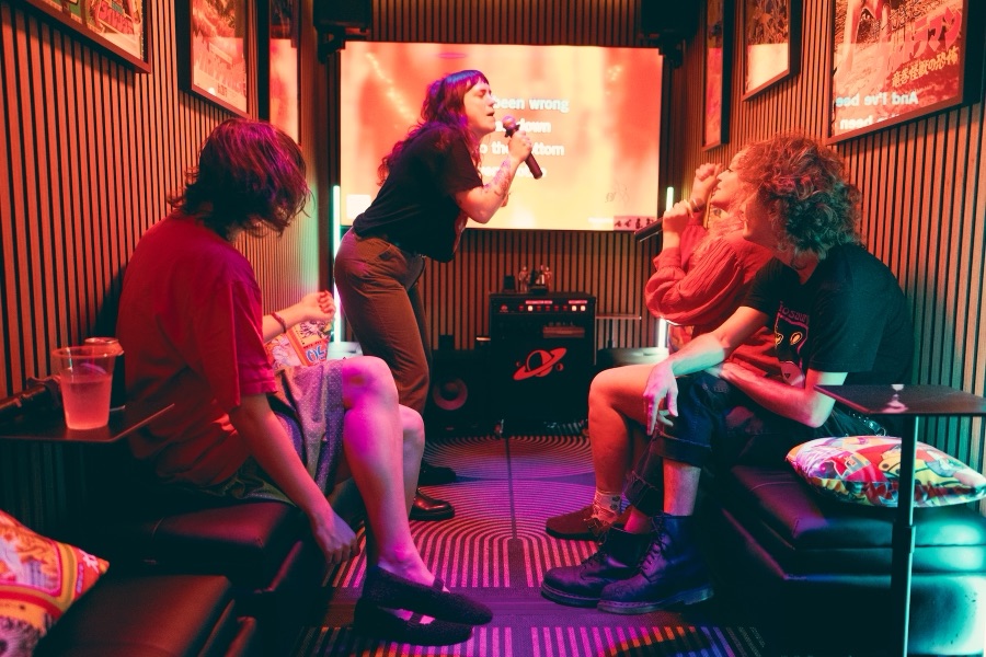 A singer performing to friends seated around the room