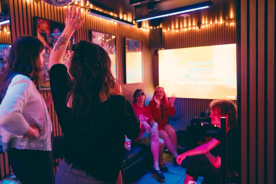 Friends watching the lyrics screen, one with a hand in the air